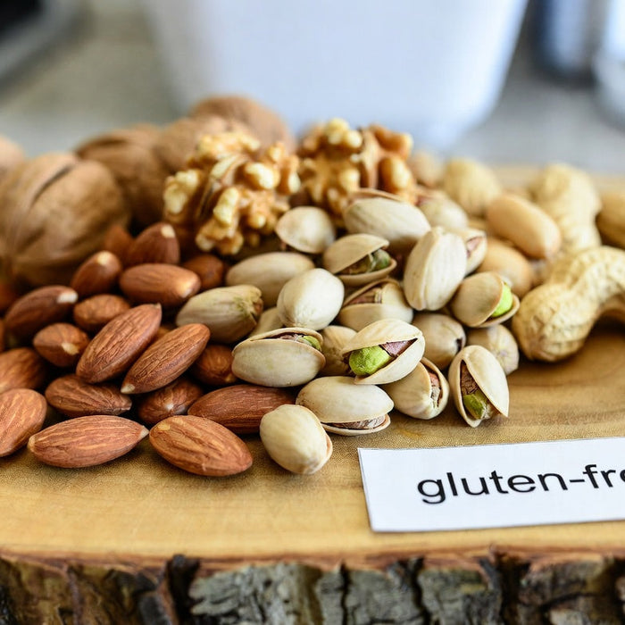 Assorted nuts on wooden board with gluten-free label in kitchen