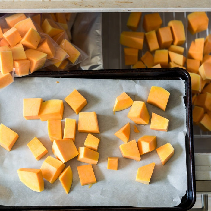 Cubed squash prepared on a tray for freezing