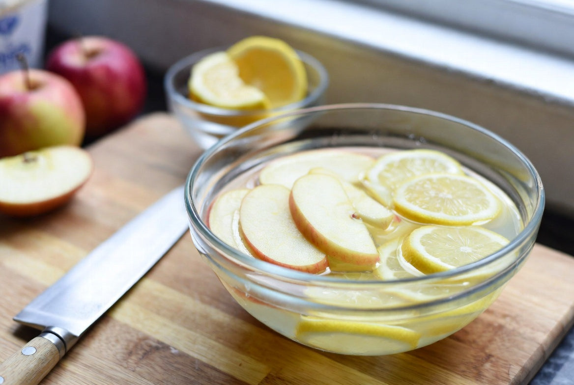 Apple slices soaking in lemon water to prevent browning