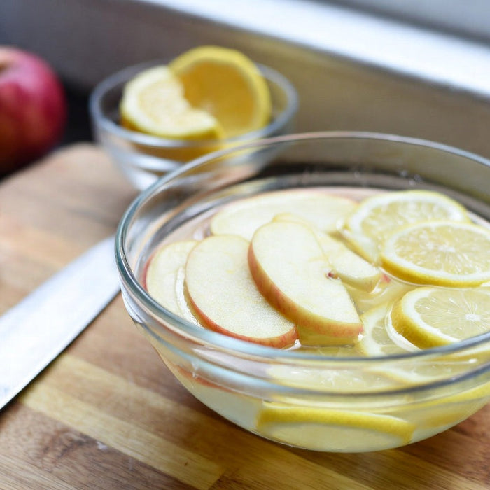 Apple slices soaking in lemon water to prevent browning