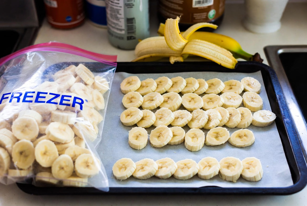 Banana slices on a tray with freezer bag ready for frozen storage home