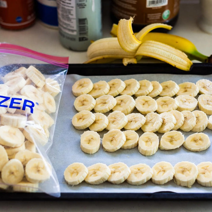 Banana slices on a tray with freezer bag ready for frozen storage home