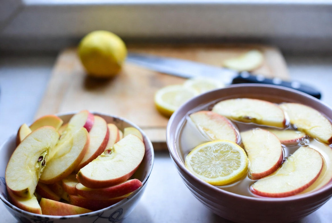 Apple slices soaking in lemon water to prevent browning