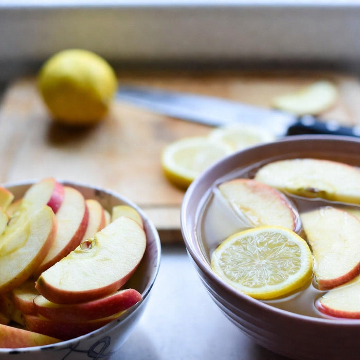 Apple slices soaking in lemon water to prevent browning