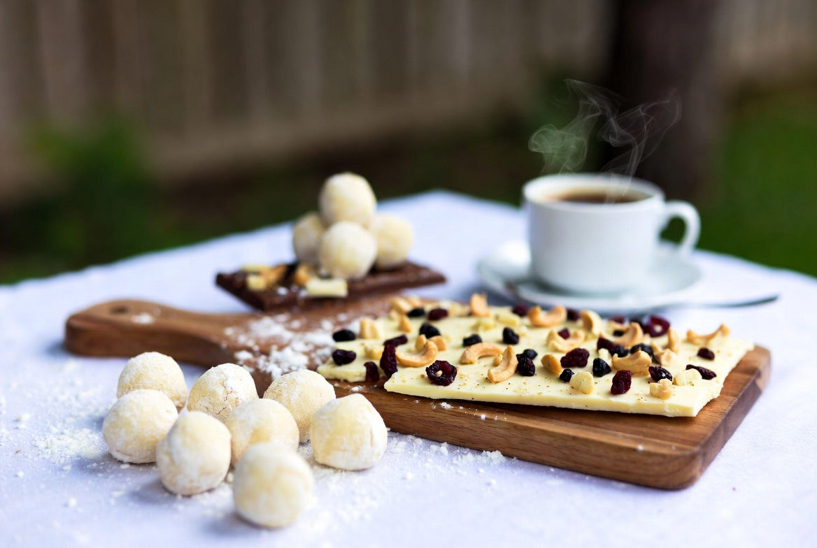 White chocolate bark and truffles with nuts, berries, and hot coffee