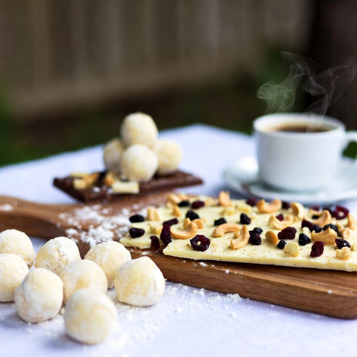 White chocolate bark and truffles with nuts, berries, and hot coffee