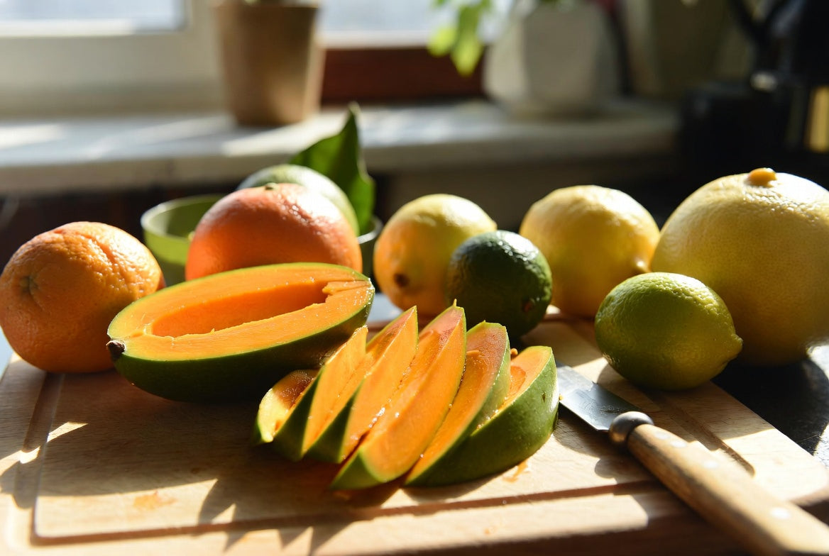 Sliced mango beside citrus fruits showing mango is not a citrus fruit