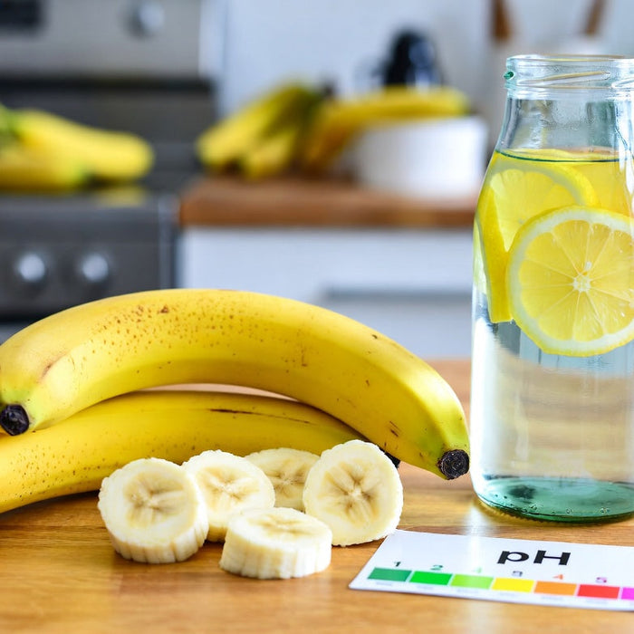 Bananas with lemon water and pH chart on kitchen counter tabletop