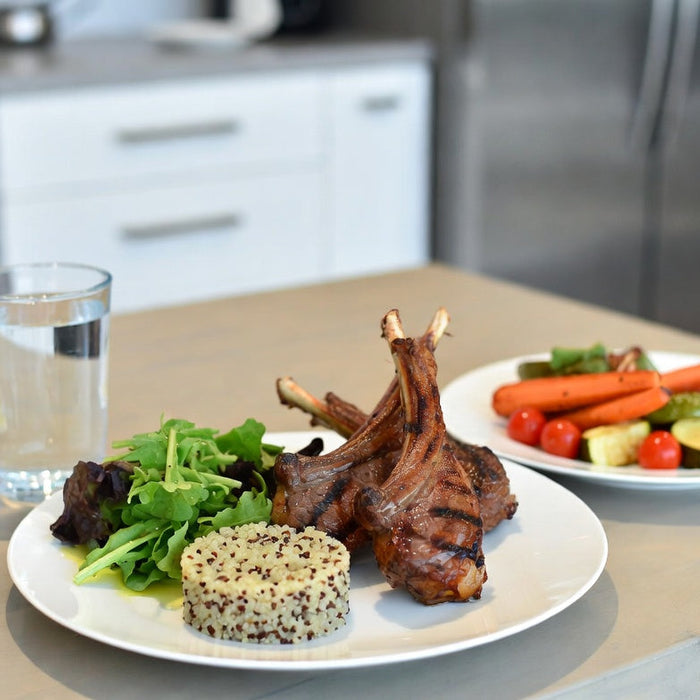 Grilled lamb chops with quinoa salad and vegetables on plate