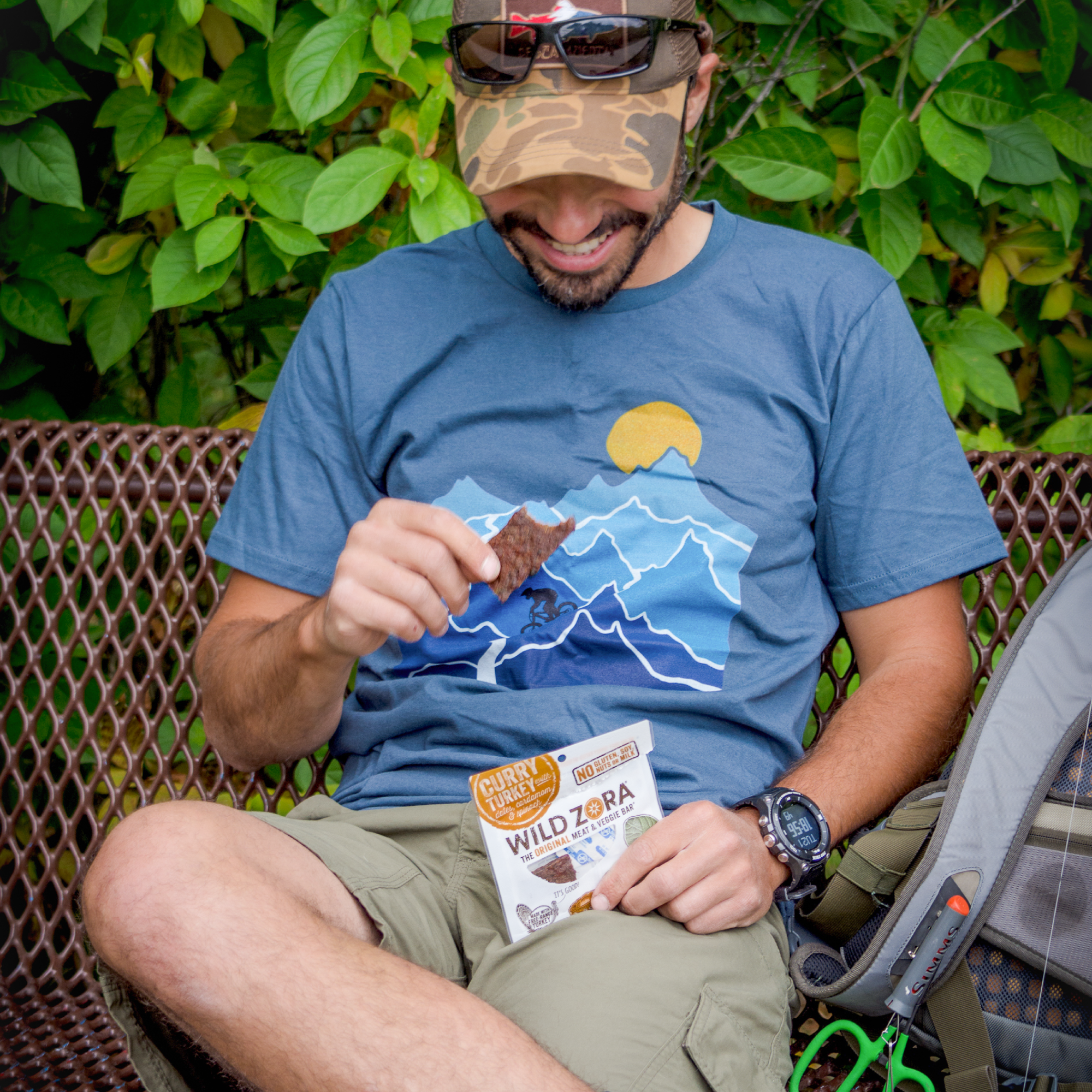 Man enjoying Wild Zora Meat & Veggie Bar Curry Turkey 1.1 oz outdoors. A high-protein, clean-ingredient snack for adventures.